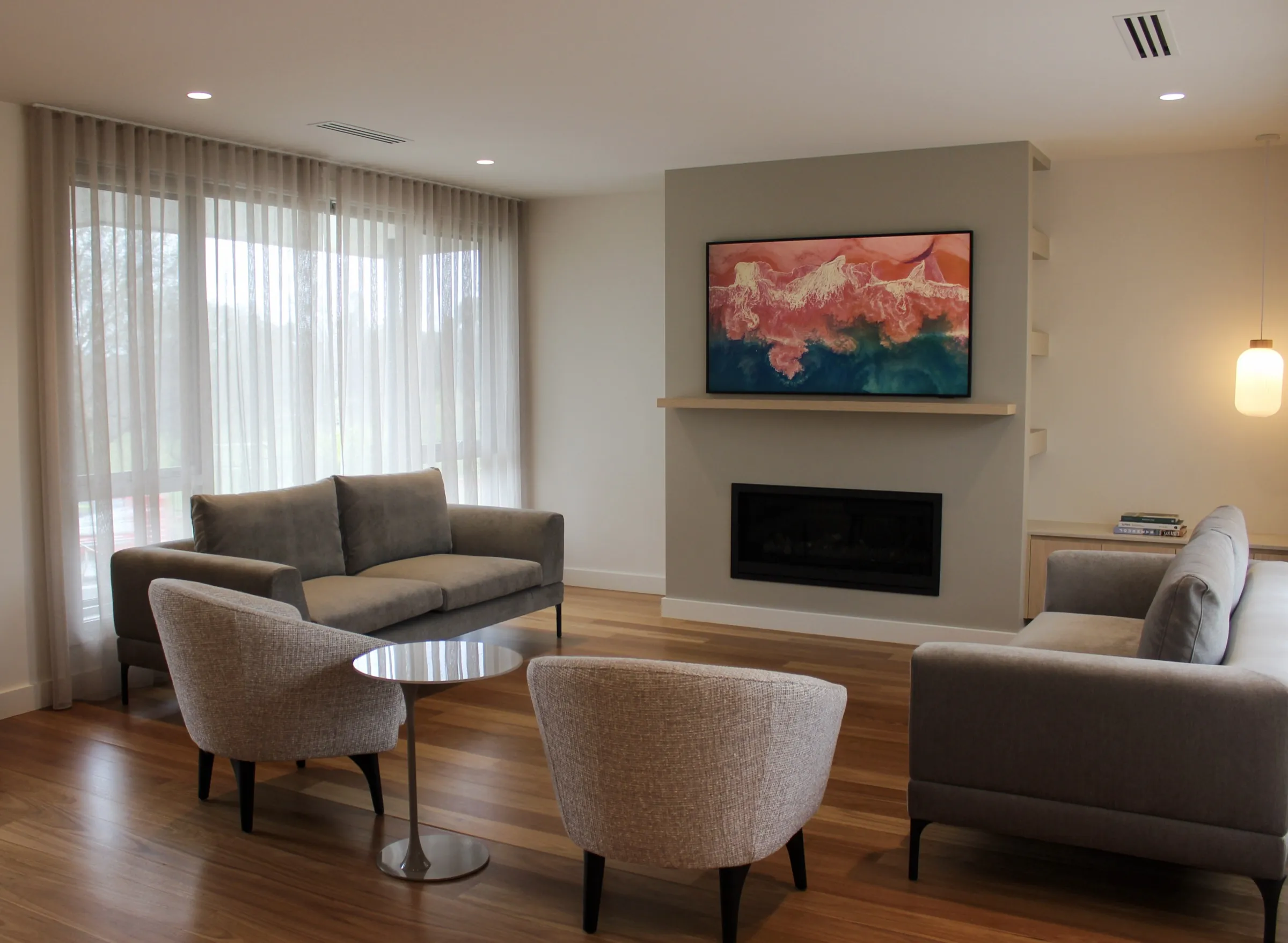 The living room at The Dalton with a gas fireplace and sheer-curtained windows